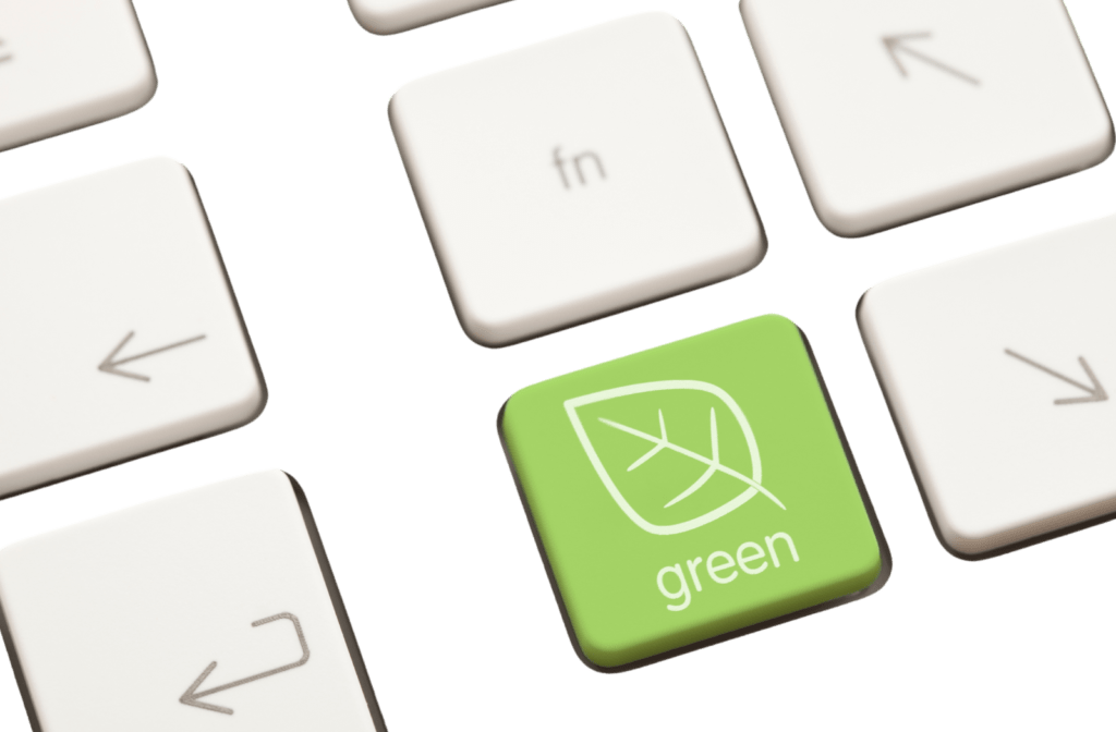 Close-up of a laptop keyboard with a green ‘Go Green’ button symbolizing sustainable digital choices.